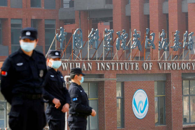  Security personnel keep watch outside the Wuhan Institute of Virology during the visit by the World Health Organization (WHO) team tasked with investigating the origins of the coronavirus disease (COVID-19), in Wuhan, Hubei province, China February 3, 2021.  (photo credit: REUTERS/THOMAS PETER/FILE PHOTO)