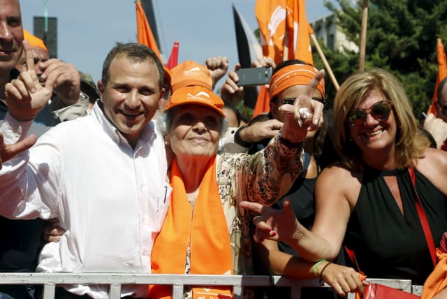 Lebanese Foreign Minister and newly elected head of the Free Patriotic Movement (FPM) Gibran Bassil (L) gestures while standing with supporters during a rally to show support for Christian politician and FPM founder Michel Aoun and to mark the October 13 anniversary, October 11, 2015. (photo credit: REUTERS/MOHAMED AZAKIR)
