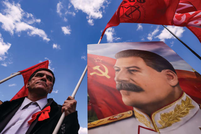  A SUPPORTER of the Russian Communist Party stands next to a portrait of Soviet leader Joseph Stalin, during a May Day rally in Moscow last year. (photo credit: MAXIM SHEMETOV/REUTERS)