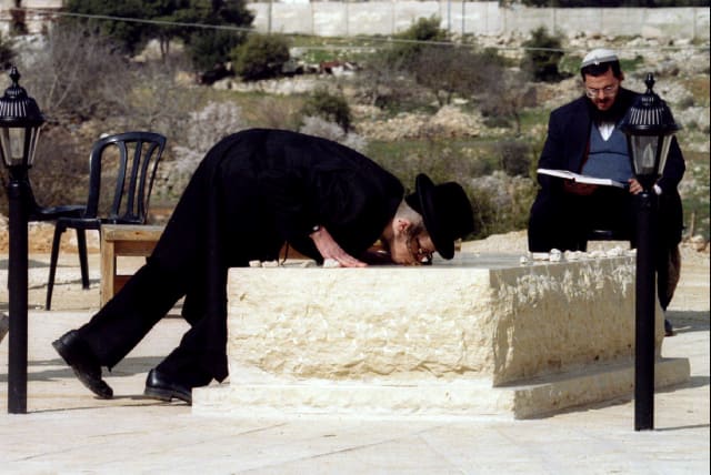  An ultra-orthodox Jew, in 1995, kisses the tombstone of Baruch Goldstein, the Israeli settler who in 1994 shot and killed 29 Palestinians as they prayed in a mosque in Hebron (photo credit: REUTERS)