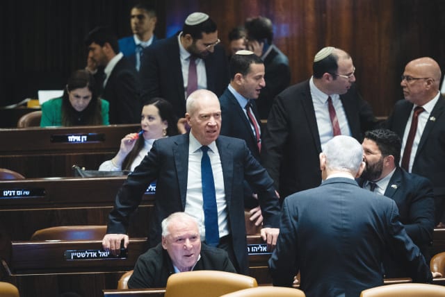  DEFENSE MINISTER Yoav Gallant stands in the center amid a flurry of activity among coalition members in the Knesset plenum, last week. The time has come for Gallant to take charge as the responsible adult, says the writer.  (photo credit: YONATAN SINDEL/FLASH90)