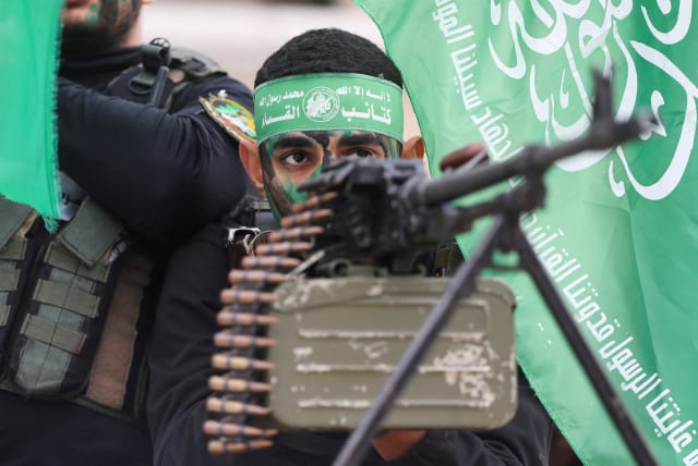  Palestinian Hamas militants take part in a rally during the 35th anniversary of Hamas founding, in Khan Younis in the southern Gaza Strip, December 14, 2022. (photo credit: REUTERS/IBRAHEEM ABU MUSTAFA)