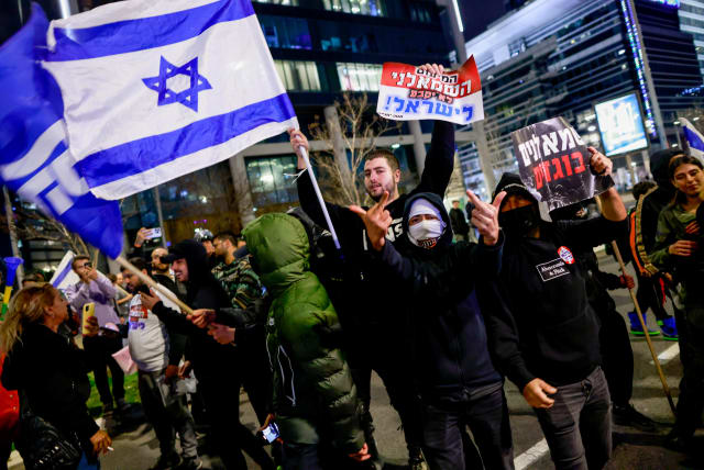  Judicial reform supporters wave Likud flags and hold signs reading "The leftist minority will not determine Israel" and "Leftist traitors" at a protest on Saturday night, March 18, 2023. (photo credit: ERIK MARMOR/FLASH90)