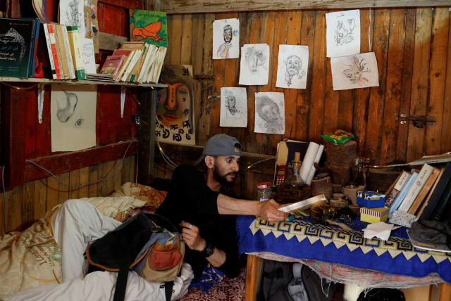  Moamen Toman, a Palestinian man, reads a book in his coffee shop in Gaza Strip January 23, 2023 (photo credit: REUTERS)