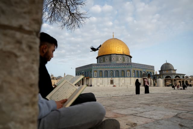  People read Koran by the Dome of the Rock on the compound known to Muslims as the Noble Sanctuary and to Jews as the Temple Mount, as Palestinians attend the first Friday of the holy month of Ramadan, in Jerusalem's Old City March 24, 2023. (photo credit: AMMAR AWAD/REUTERS)
