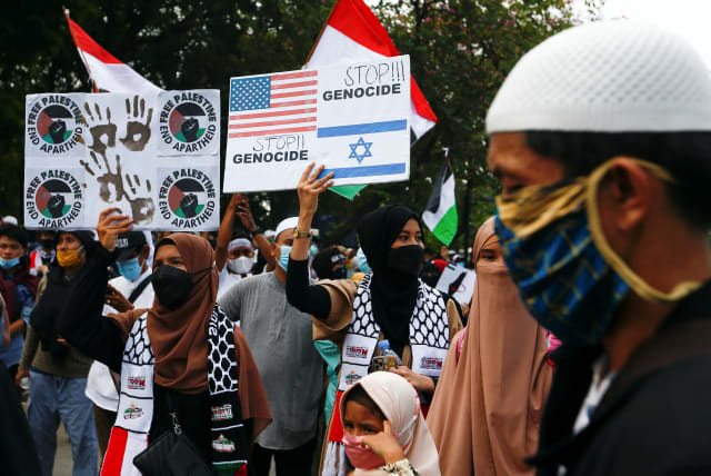  People carry placards during a protest against Israel outside the U.S. embassy in Jakarta, Indonesia, May 21, 2021.  (photo credit: REUTERS/AJENG DINAR ULFIANA)