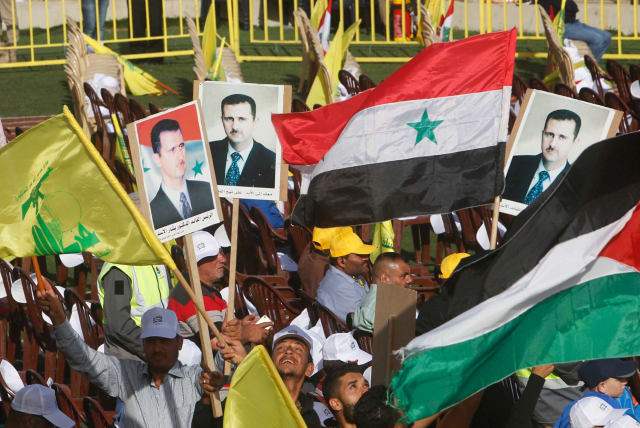  Supporters of Lebanon's Hezbollah leader Sayyed Hassan Nasrallah carry flags and pictures of Syria's President Bashar al-Assad during a rally marking al-Quds Day, (Jerusalem Day) in Maroun Al-Ras village, near the border with Israel, southern Lebanon June 8, 2018. (photo credit: REUTERS/AZIZ TAHER)