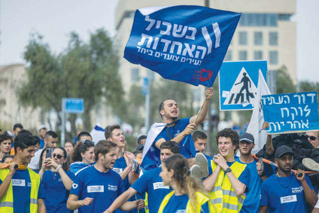  YOUTH DEMONSTRATE near the Knesset, last month. The flag reads: ‘For the unity: Youth march together.’ Don’t bet against Israel, it’s been counted out many times, and always bounced back strongly, says the writer. (photo credit: YONATAN SINDEL/FLASH90)