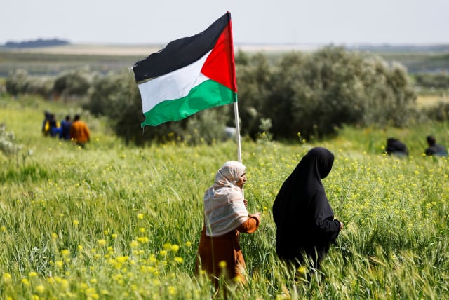 Palestinians hold flags as they mark 'Land Day', an annual commemoration of six Arab citizens of Israel who were killed by Israeli security forces during demonstrations over land confiscations in 1976, in the east of Gaza Strip, March 30, 2023. (photo credit: REUTERS/MOHAMMED SALEM)