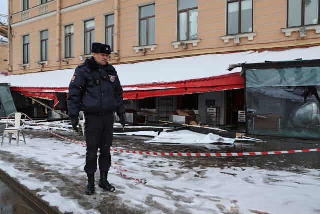 A police officer stands guard at the scene of the cafe explosion in which Russian military blogger Vladlen Tatarsky, (real name Maxim Fomin) was killed the day before in Saint Petersburg, Russia April 3, 2023. (photo credit: ANTON VAGANOV/ REUTERS)