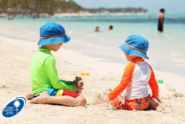  Two children sit on the beach. (photo credit: ISRAEL CANCER ASSOCIATION)