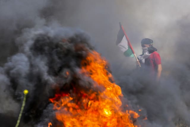  Palestinian demonstrators burn tires during a protest over tension in Jerusalem, at the Israel-Gaza border fence, east of Gaza City April 5, 2023. (photo credit: ATIA MOHAMMED/FLASH90)