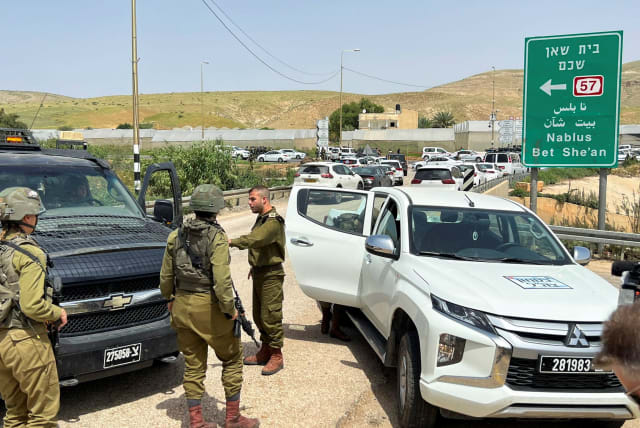 Israeli troops stand guard at a shooting attack scene, in the Jordan Valley in the West Bank April 7, 2023 (photo credit: REUTERS/RAMI AMICHAY)