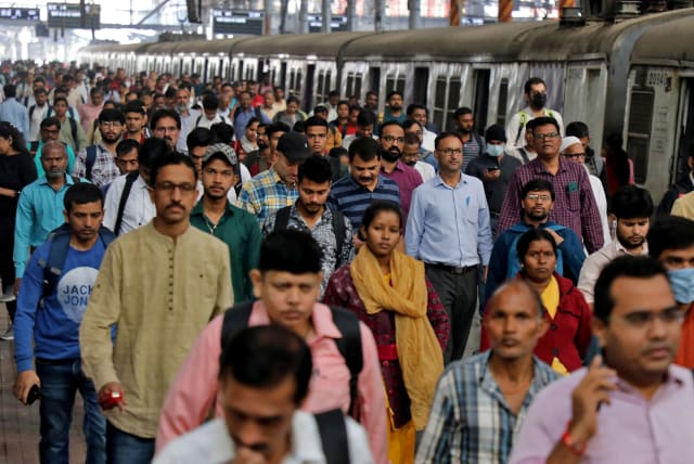  Commuters walk on a platform after disembarking from a suburban train at a railway station in Mumbai, India, January 21, 2023. (photo credit: REUTERS/NIHARIKA KULKARNI)
