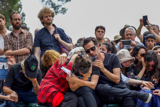 Friends and family members mourn during the funeral ceremony of Israeli author Yehonatan Geffen in Nahalal cemetery, northern Israel, April 21, 2023 (photo credit: SNIR TOREM/FLASH90)