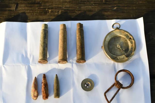  A compass, bullet shells, a button and a grenade pin found on the battle hill. (photo credit: YULI SCHWARTZ/IAA)