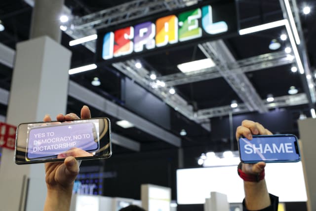  People protest with their cellphones as Israel’s Economy Minister Nir Barkat (not pictured) speaks at the 2023 Mobile World Congress (MWC) in Barcelona on February 27. (photo credit: NACHO DOCE/REUTERS)