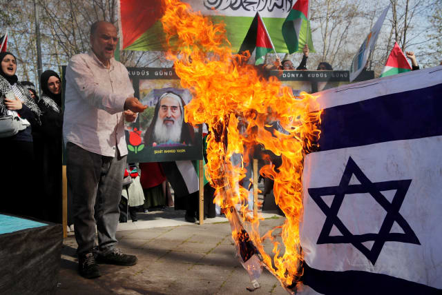 Pro-Palestinian demonstrators set fire to an Israeli flag during a rally to mark the annual al-Quds Day (Jerusalem Day), during the holy month of Ramadan in Istanbul, Turkey April 14, 2023.  (photo credit: REUTERS/DILARA SENKAYA)