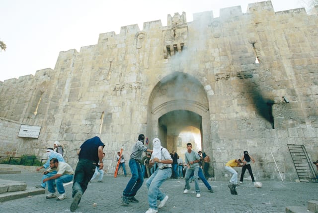  YOUNG ARABS riot at the Lions’ Gate in Jerusalem’s Old City, in October 2000, the beginning of the Second Intifada. Yasser Arafat rejected Ehud Barak’s concessions, and declared a more violent conflict.  (photo credit: NATI SHOHAT/FLASH90)