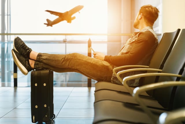  A man waits for a flight in the airport (illustrative) (photo credit: PEXELS)