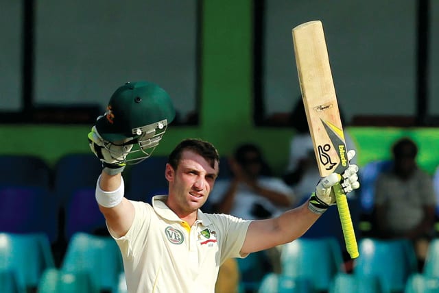  Phillip Hughes raises his bat after scoring a century (100 runs) during the team’s fourth day of their third and final cricket match against Sri Lanka in Colombo on September 19, 2011.  (photo credit: DINUKA LIYANAWATTE/REUTERS)