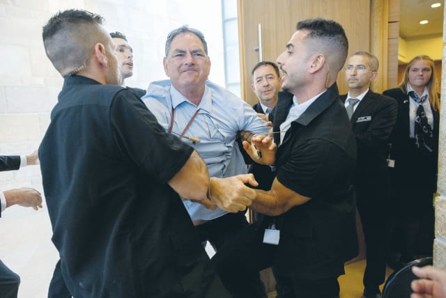  HIZKY SIVAK of the Emek Hefer Regional Council is removed by security personnel from a stormy meeting and vote at the Knesset Finance Committee on the Arnona Fund, last Monday. (photo credit: YONATAN SINDEL/FLASH90)