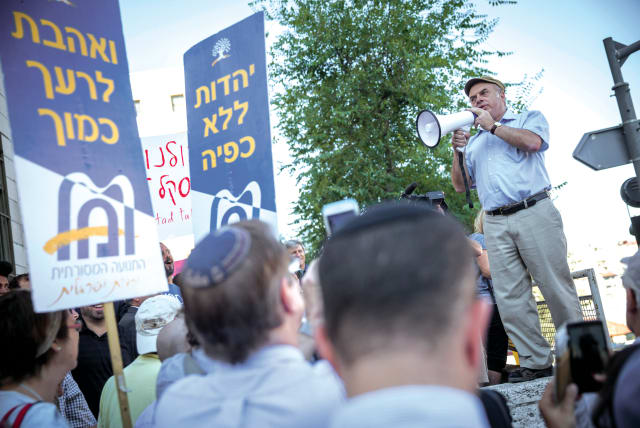  THEN-JEWISH AGENCY CHAIRMAN Natan Sharansky speaks at a protest held outside the Chief Rabbinate in Jerusalem, in 2016. The signs read ‘Love your neighbor as yourself’ and ‘Judaism without coercion.’ (photo credit: HADAS PARUSH/FLASH90)