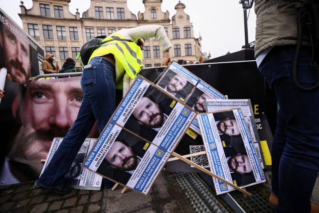 A person arranges placards during a protest against the detention of Belgian aid worker Olivier Vandecasteele in Iran, who was sentenced to 40 years in prison and 74 lashes on charges including spying, in Brussels, Belgium January 22, 2023. (photo credit: YVES HERMAN/REUTERS)