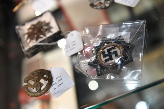 Exhibits from the Nazi era are seen in a cupboard at the auction house Hermann Historica in Munich, Germany, November 20, 2019. Several hundred Nazi objects were up for auction, amongst them Adolf Hitler's hat and one of Eva Braun's dresses. (photo credit: ANDREAS GEBERT/REUTERS)