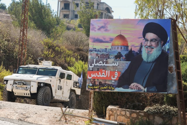  A UN peacekeepers (UNIFIL) vehicle drives near a picture showing Lebanon's Hezbollah leader Sayyed Hassan Nasrallah in Adaisseh village, near the Lebanese-Israeli border, southern Lebanon, October 11, 2022 (photo credit: REUTERS/AZIZ TAHER)