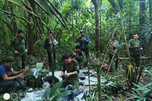  Colombian military soldiers attend to child survivors from a Cessna 206 plane that crashed in the jungles of Caqueta, in limits between Caqueta and Guaviare, June 9, 2023. (photo credit: Colombian Military Forces/Handout via REUTERS)