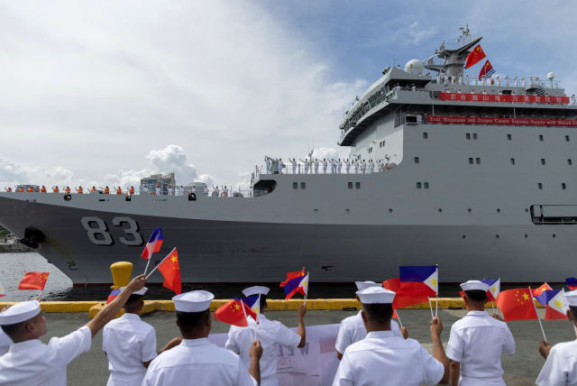  Philippine Navy personnel wave the national flags of China and the Philippines as the Chinese naval training ship "Qi Jiguang" docks at the Port of Manila for a four-day goodwill visit, in Manila, Philippines, June 14, 2023. (photo credit: ELOISA LOPEZ/ REUTERS)