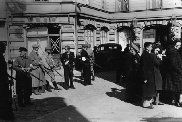  Members of Latvian Auxiliary Police assemble a group of Jews, Liepāja, July, 1941. (photo credit: Wikimedia Commons)