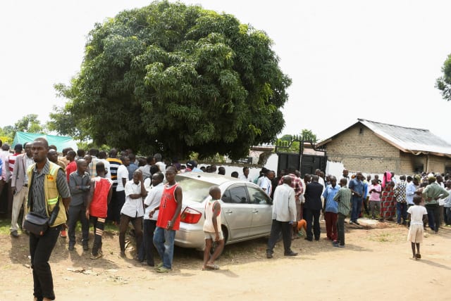 Locals gather at the cordoned scene outside the Mpondwe Lhubirira Secondary School, after militants linked to rebel group Allied Democratic Forces (ADF) killed and abducted multiple people, in Mpondwe, western Uganda, June 17, 2023. (photo credit: REUTERS)