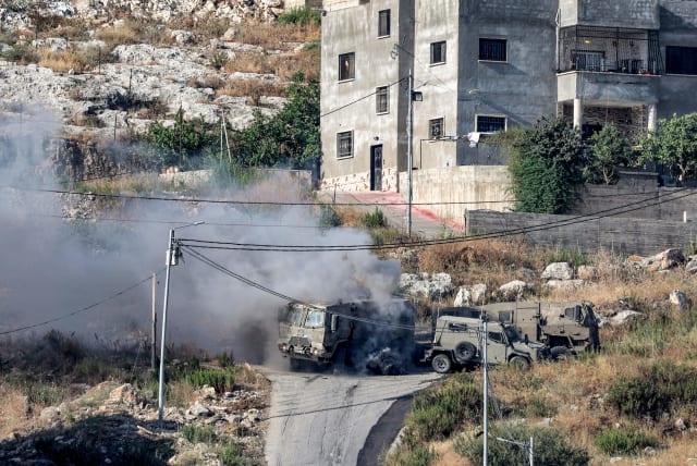 Smoke billows from the aftermath of the detonation of a Palestinian explosive charge on an Israeli armoured vehicle during an Israeli army raid in Jenin in the West Bank on June 19, 2023. (photo credit: JAAFAR ASHTIYEH/AFP via Getty Images)