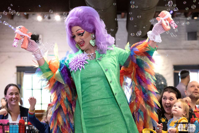  "Tara Hoot", a Drag Queen originally from Terre Haute, Indiana, uses bubble makers above audience members during a Drag Story Hour at Crazy Aunt Helen's restaurant in the Eastern Market neighborhood of Washington, U.S., April 29, 2023. (photo credit: REUTERS)
