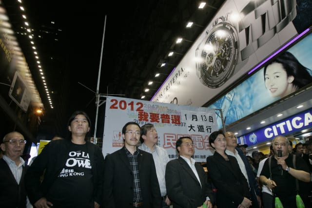  An antenna is set up on a street in Hong Kong's Mongkok shopping district as pro-democracy activists Leung Kwok-hung (2nd L) and Tsang Kin-shing (R), a host at Citizens' Radio, along with pro-democracy lawmakers Emily Lau (3rd R) and Lee Wing-tat (4th R), take part in a broadcast despite a governme (photo credit: REUTERS/Bobby Yip/File Photo)