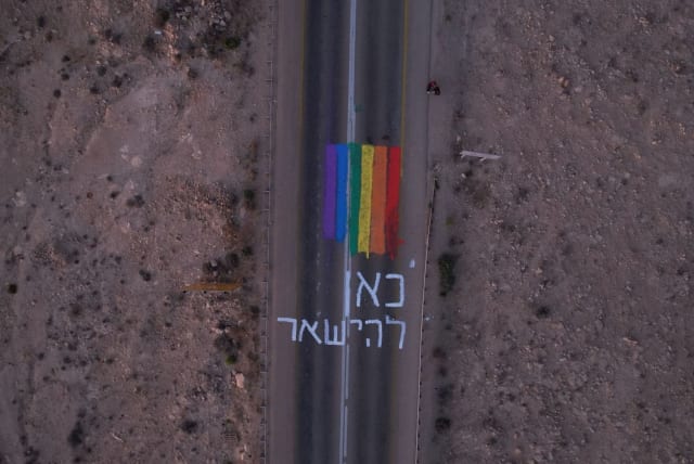  A Pride flag and the words "here to stay" on a road at the entrance to Mitzpe Ramon. (photo credit: Via Maariv)