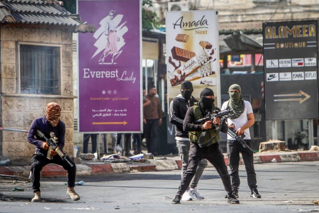  Palestinians carrying weapons seen as Israel began a major aerial and ground offensive in the West Bank city of Jenin, in one of its biggest military operation in the Palestinian territory in years. July 3, 2023.  (photo credit: NASSER ISHTAYEH/FLASH90)