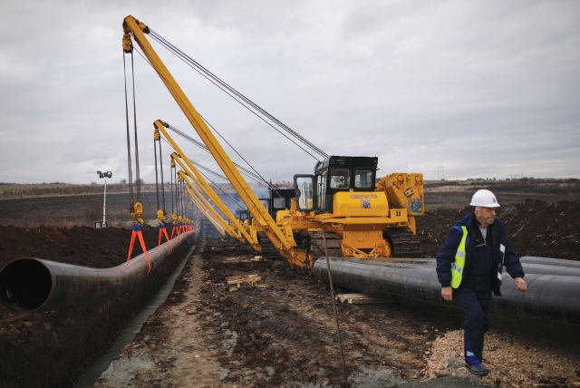  A WORKER walks next to a pipe at the launch of the construction of an interconnector gas pipeline to link the gas networks of Bulgaria and Serbia, near Golyanovtsi, Bulgaria, February 1, 2023. Start investing. Keep it simple: Stick to stocks, bonds, and real estate, says the writer.  (photo credit: STOYAN NENOV/REUTERS)