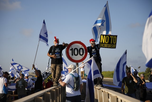  Anti-judicial overhaul demonstrators block a main road at the entrance to Haifa, during a protest against the judicial overhaul on July 11, 2023. (photo credit: SHIR TOREM/FLASH90)