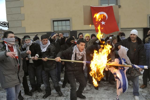 Demonstrators set fire to an Israeli flag during an anti-Israeli rally in Stockholm January 10, 2009. Several thousand demonstrators marched to the Israeli embassy, protesting against the military action in the Gaza Strip. REUTERS (photo credit: REUTERS/ SCANPIX/ Leif R Jansson)