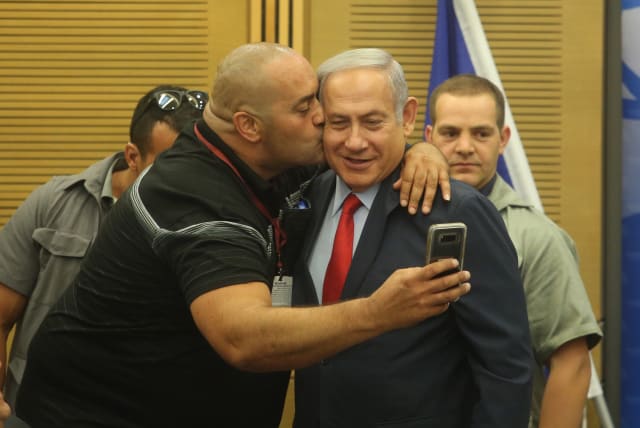  Prime Minister Benjamin Netanyahu poses for a selfie with Itzik Zarka, a Likud activist and fan, during a Likud party faction meeting at the Knesset. (photo credit: MARC ISRAEL SELLEM)