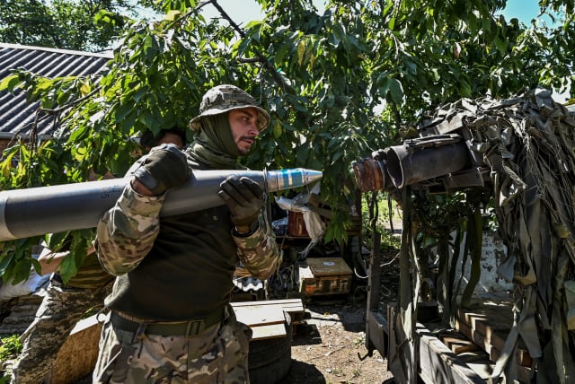  Ukrainian servicemen load a shell into a Partyzan small multiple rocket launch system before firing toward Russian troops at a position near a front line, amid Russia's attack on Ukraine, in Zaporizhzhia region, Ukraine July 13, 2023. (photo credit: REUTERS/STRINGER)