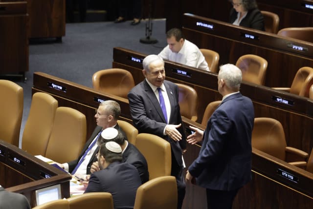  Israeli Prime Minister Benjamin Netanyahu and National Unity leader MK Benny Gantz are seen moving to shake hands in the Knesset amid the vote on the controversial reasonableness standard bill, in Jerusalem, on Monday, July 24, 2023. (photo credit: MARC ISRAEL SELLEM/THE JERUSALEM POST)