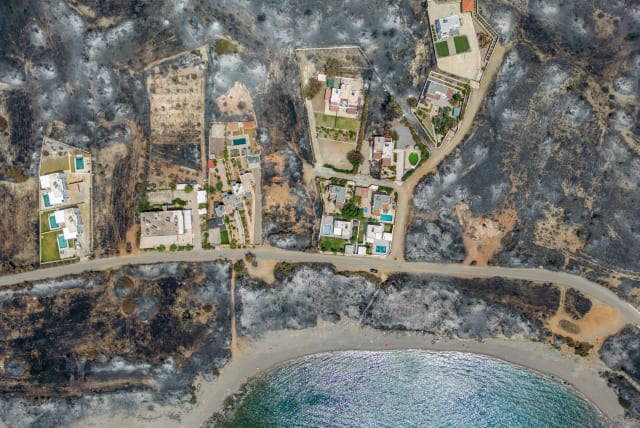  An aerial view of houses among burned land, as a wildfire burns on the island of Rhodes, Greece July 27, 2023. (photo credit: NICOLAS ECONOMOU/REUTERS)