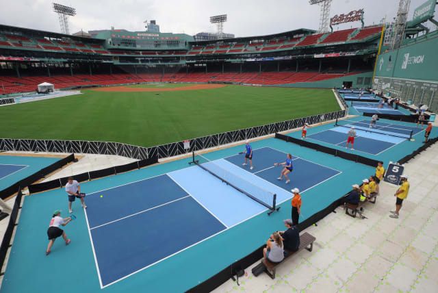 Competitors play pickleball on courts set up in the outfield of Fenway Park, home of Major League Baseball’s Boston Red Sox, during the 2023 Ballpark Series in Boston, Massachusetts, U.S., July 14, 2023. (photo credit: REUTERS/BRIAN SNYDER)