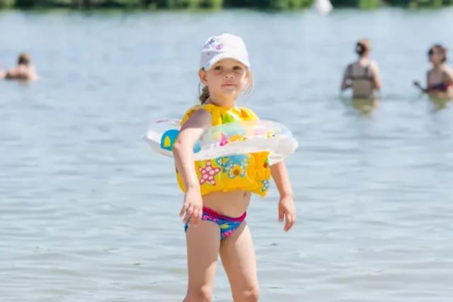  A small child is ready for some swimming fun by the water. (photo credit: MAARIV)