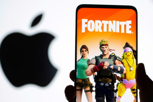  Fortnite game graphic is displayed on a smartphone in front of Apple logo in this illustration taken May 2, 2021. (photo credit: REUTERS/DADO RUVIC/ILLUSTRATION/FILE PHOTO)