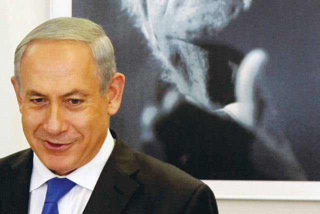  PRIME MINISTER Benjamin Netanyahu stands in front of a portrait of first prime minister David Ben-Gurion. (photo credit: EDI ISRAEL/FLASH90)